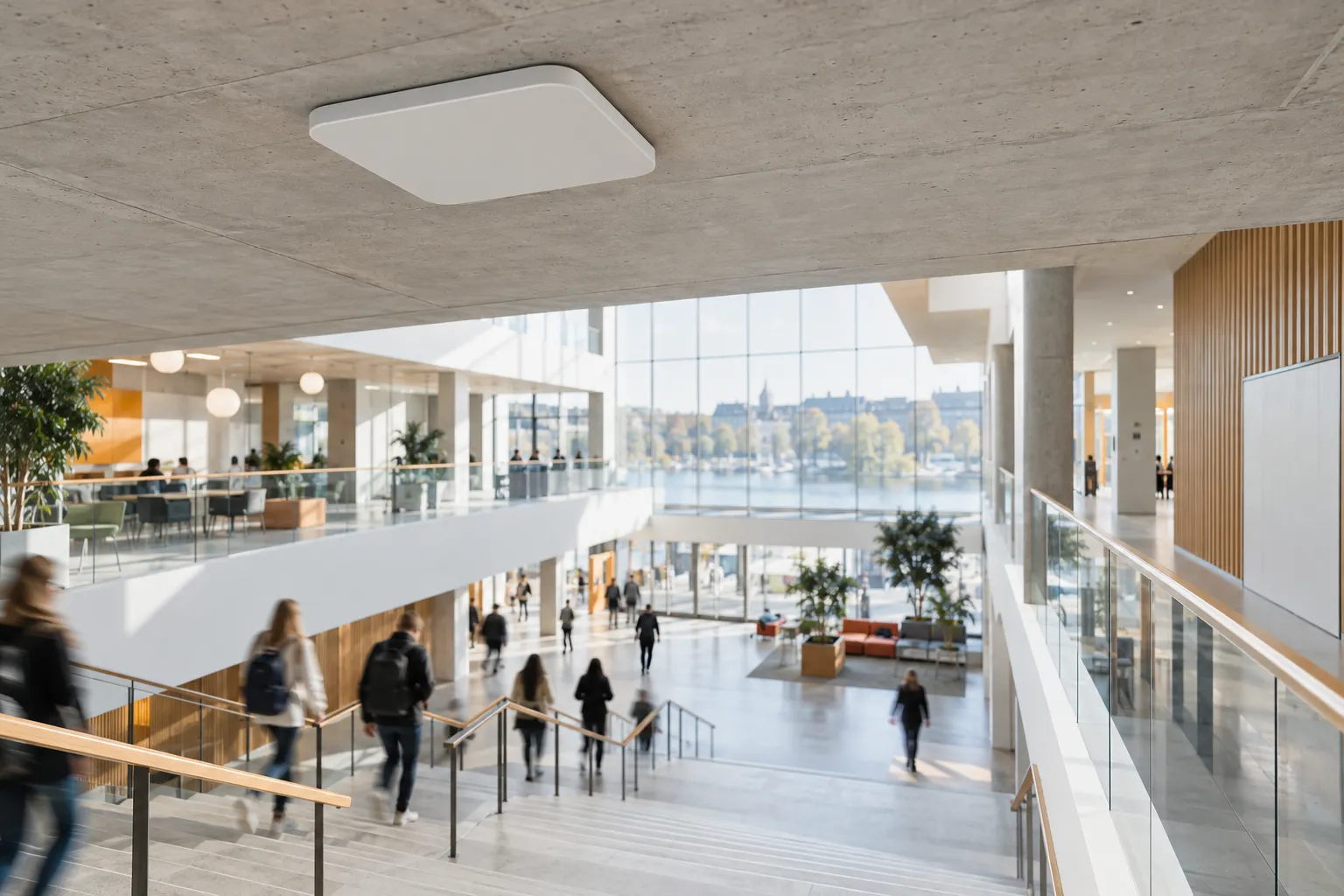 Et takmontert Wi-Fi-aksesspunkt i bedriftsklasse over mennesker i bevegelse gjennom et lyst offentlig rom.